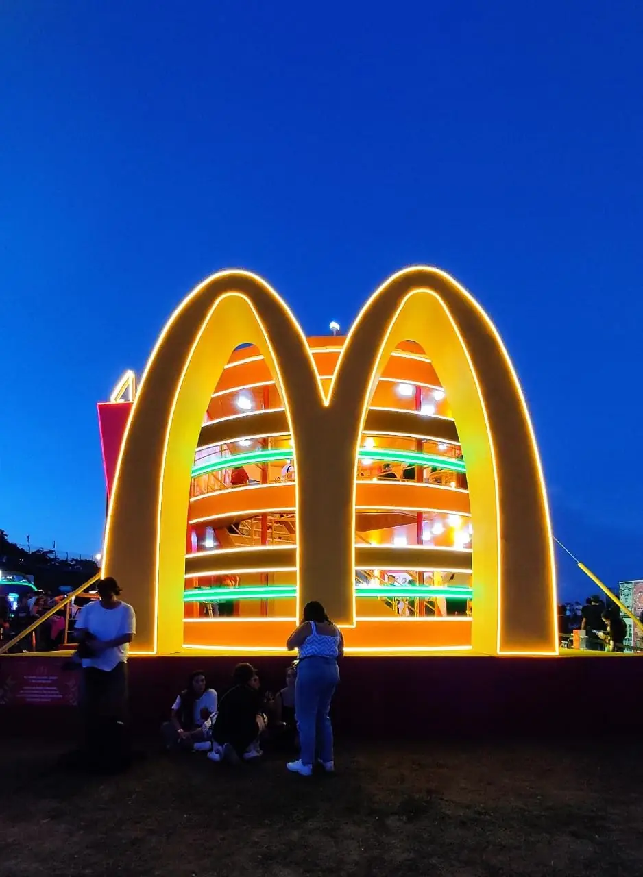 Estande do McDonald's iluminado à noite durante o festival